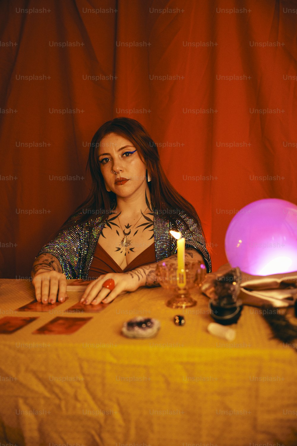 a woman sitting at a table with a lit candle
