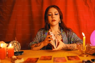 a woman sitting at a table holding a piece of paper