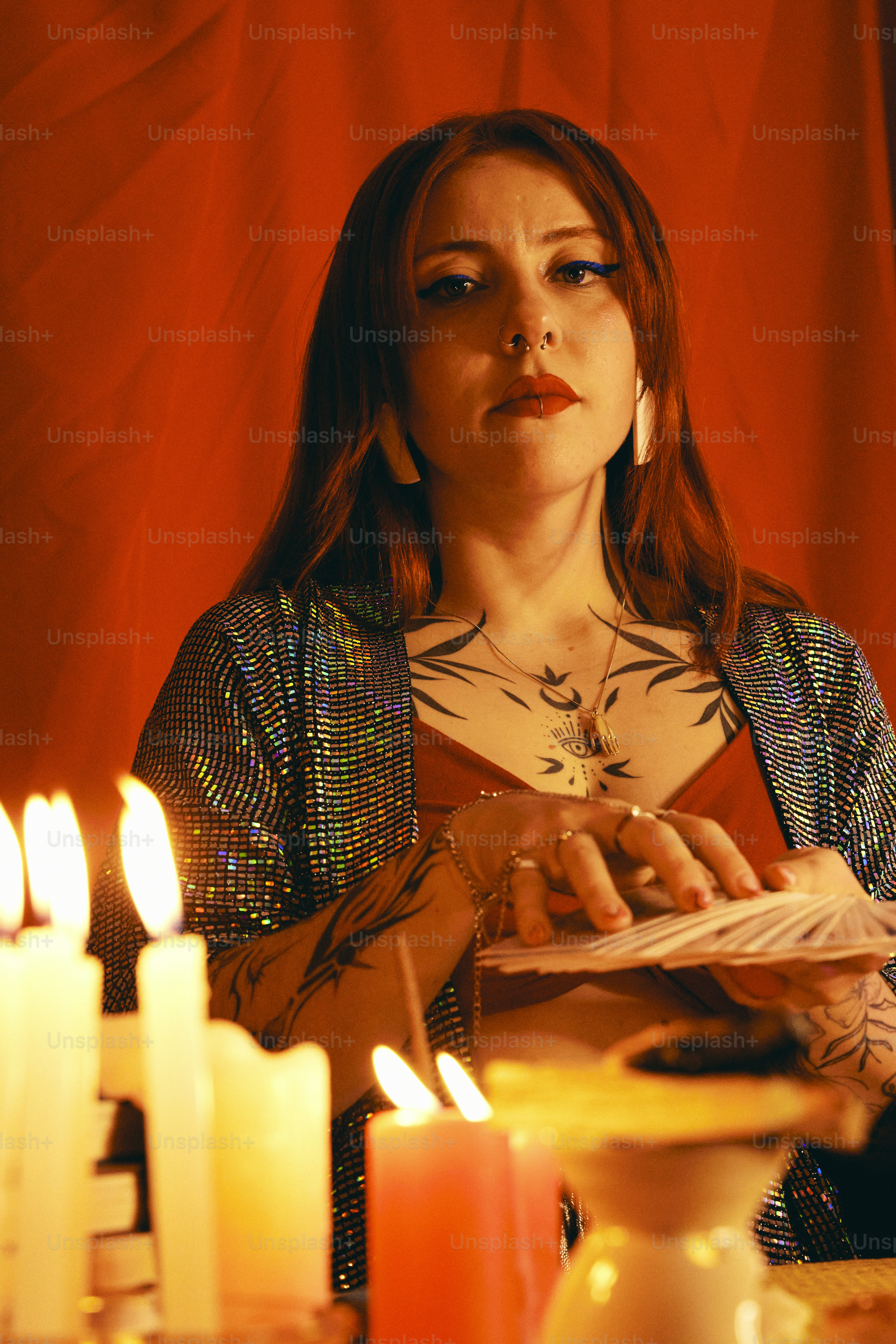 a woman sitting at a table with candles in front of her