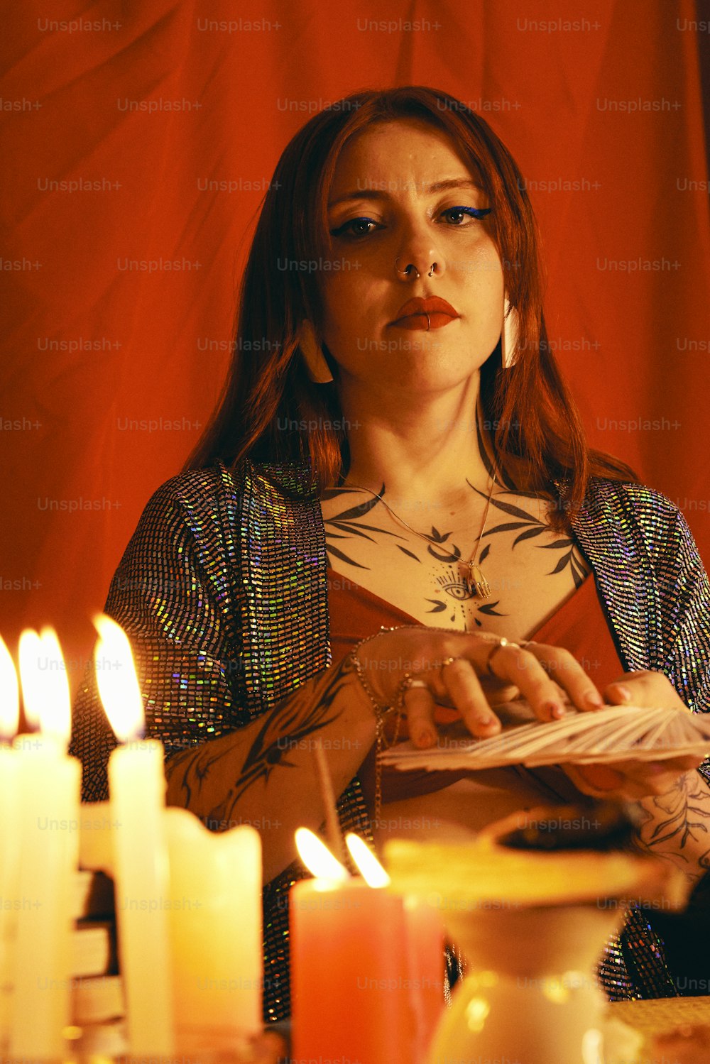 uma mulher sentada em uma mesa com velas à sua frente