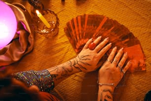 a woman's hands holding a fan on a table