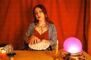 a woman sitting at a table with a lit candle