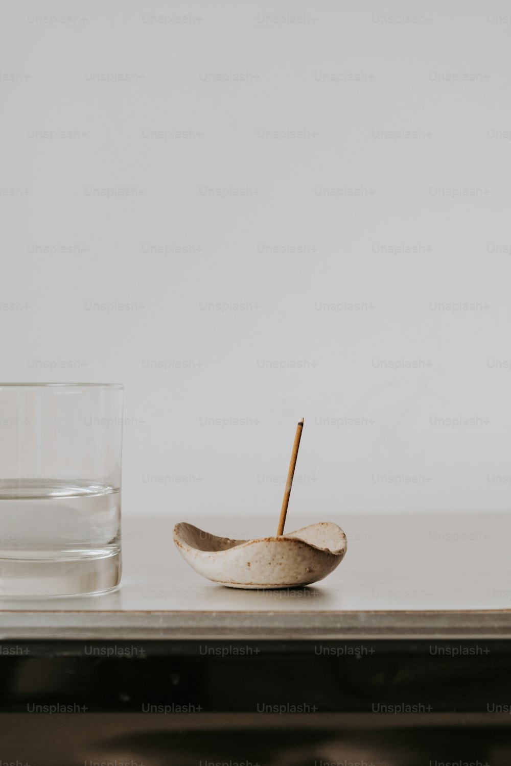 コップ一杯の水とテーブルの上の木のスプーン