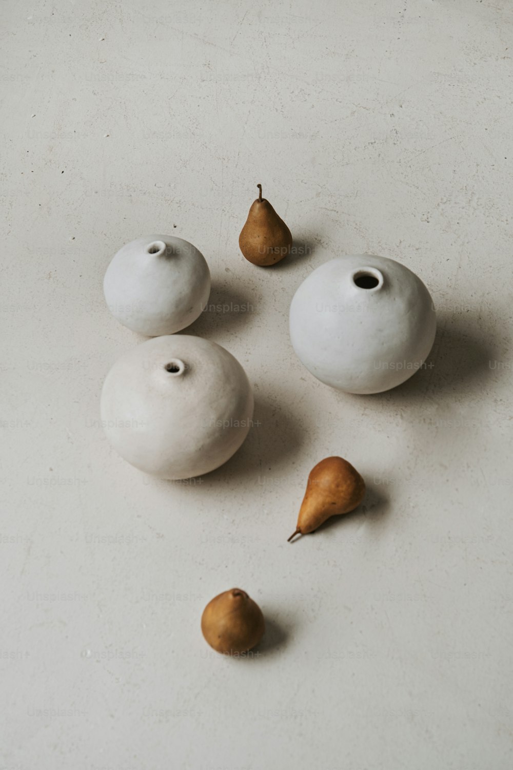 Un grupo de tres jarrones blancos sentados encima de una mesa