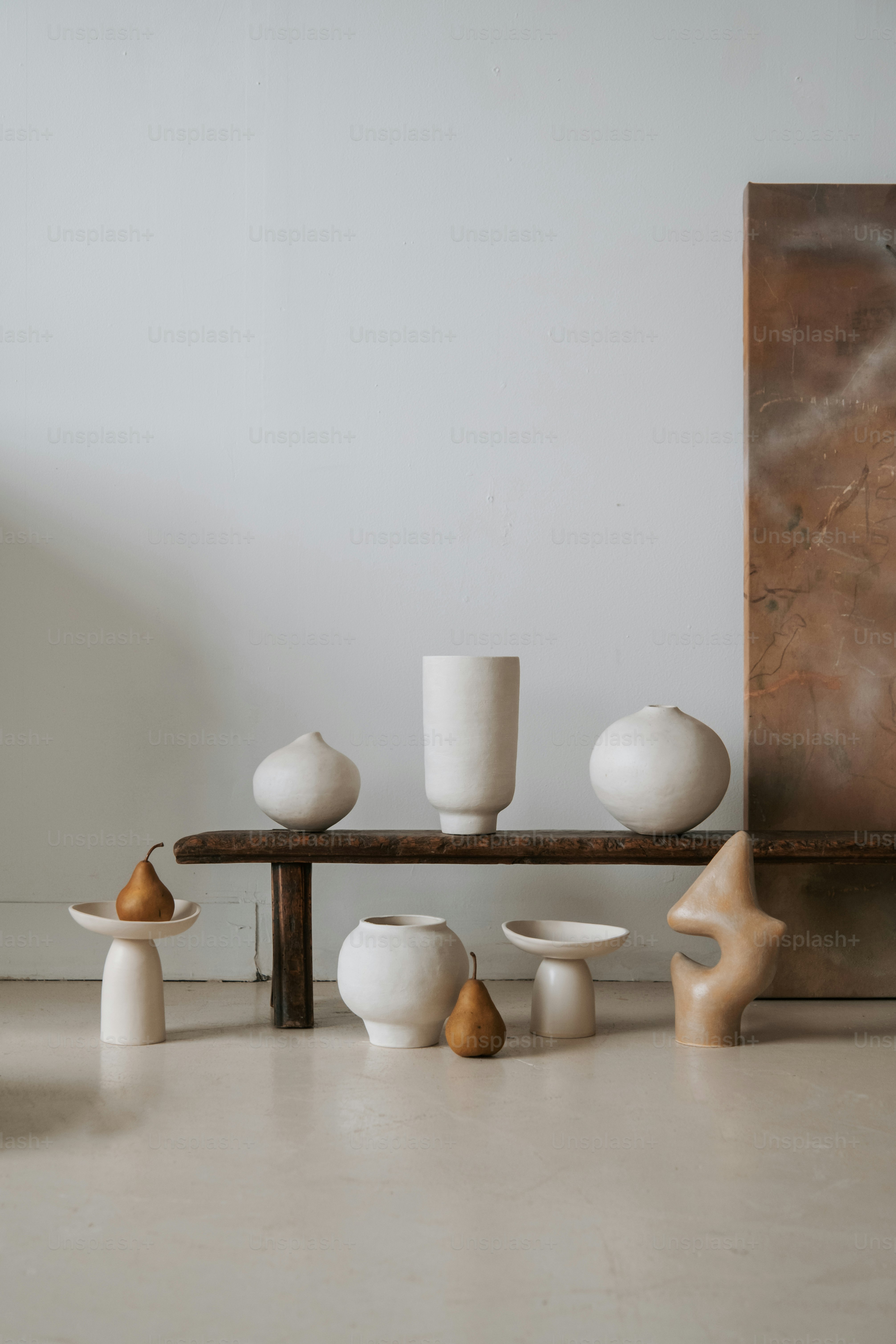 a group of white vases sitting on top of a wooden table