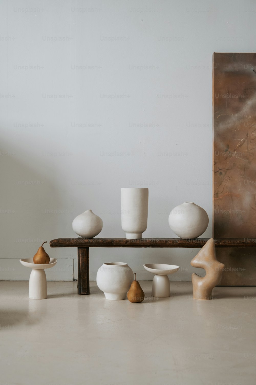 Eine Gruppe weißer Vasen, die auf einem Holztisch sitzen