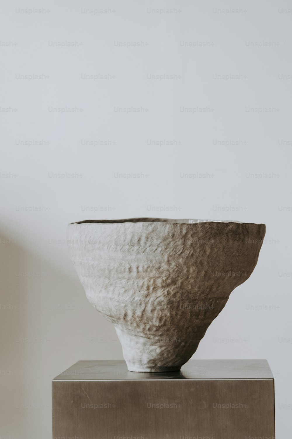 a white bowl sitting on top of a metal stand