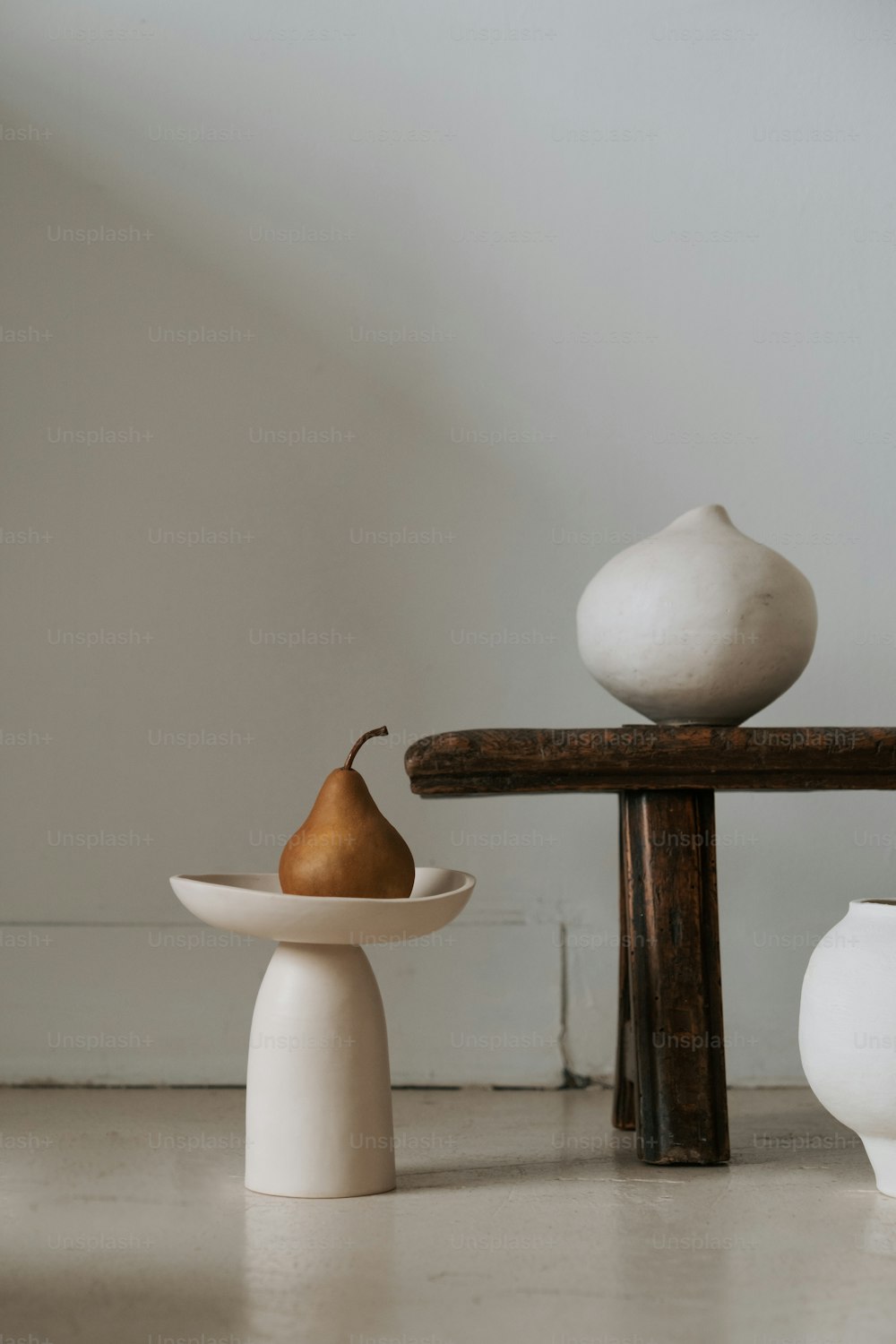 drei weiße Vasen, die auf einem Tisch sitzen