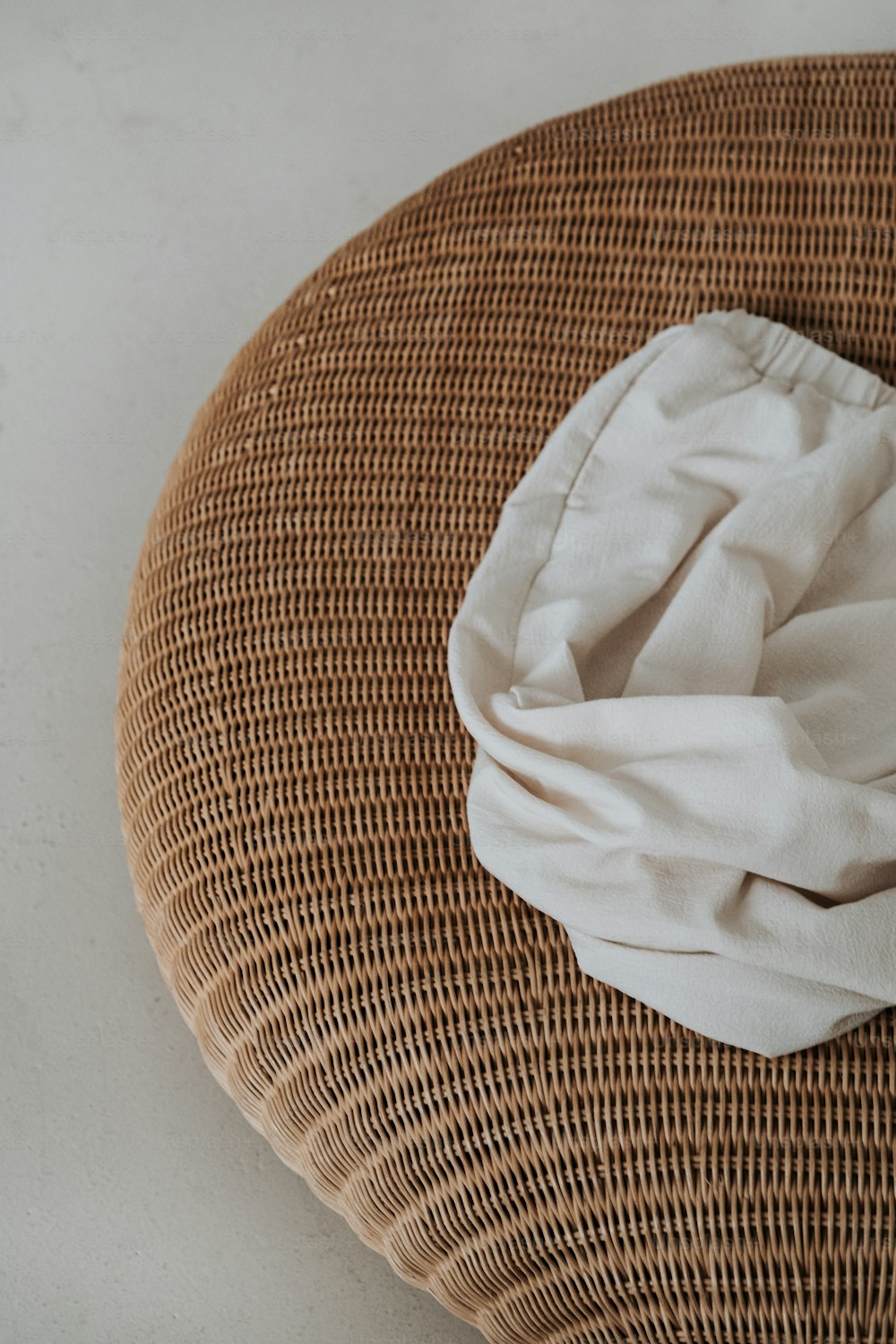 a white cloth is on top of a wicker chair