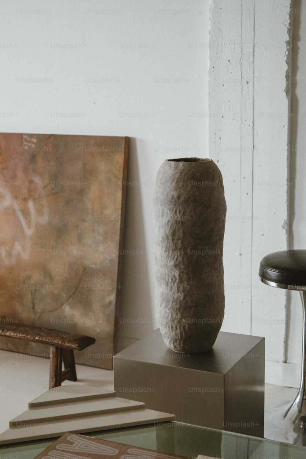 um vaso sentado em cima de uma mesa ao lado de uma pintura