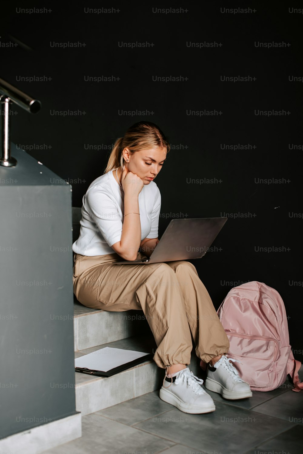 노트북 컴퓨터를 사용하여 계단에 앉아 있는 여자