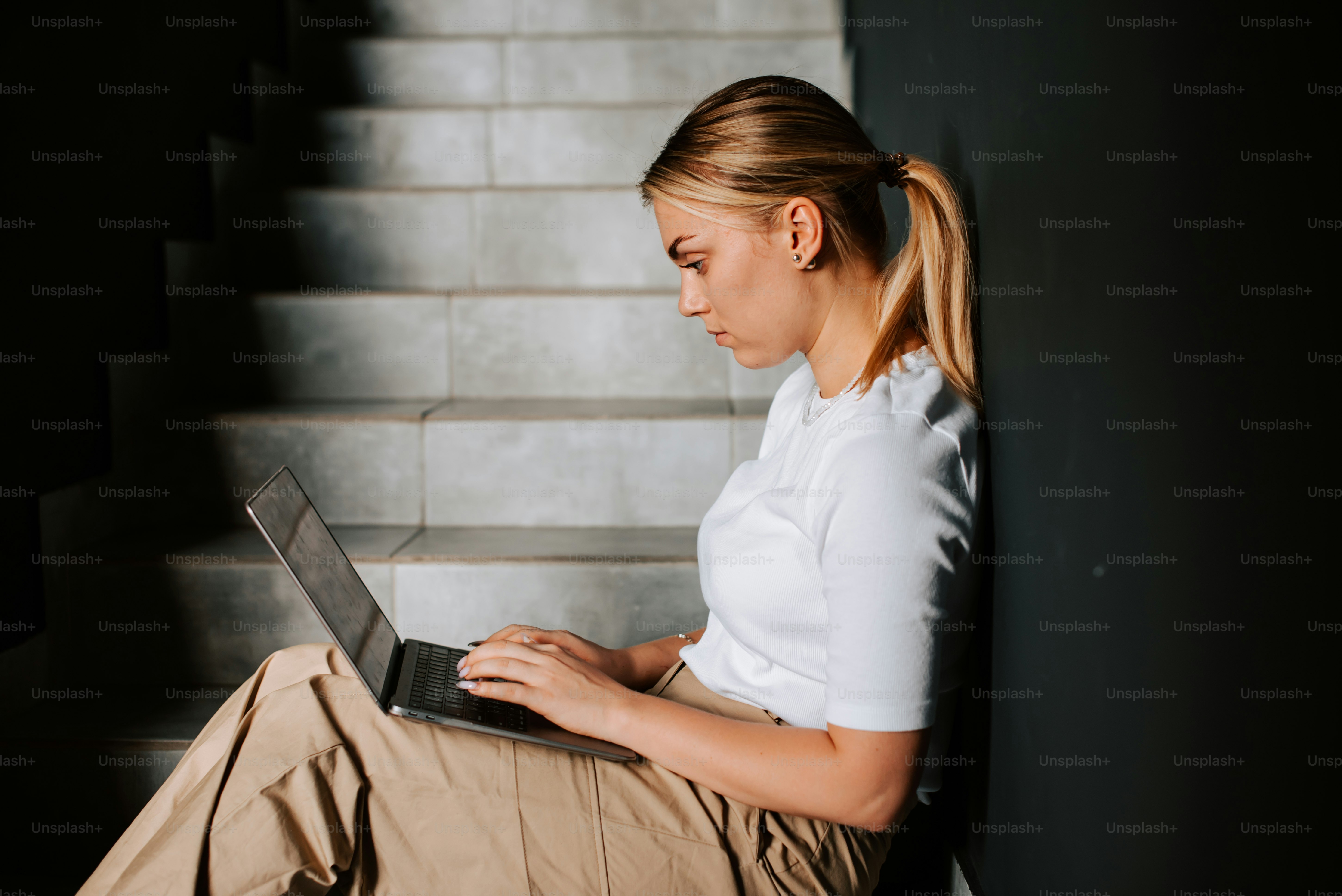 A woman sitting at a table using a laptop computer photo – Laptop Image ...