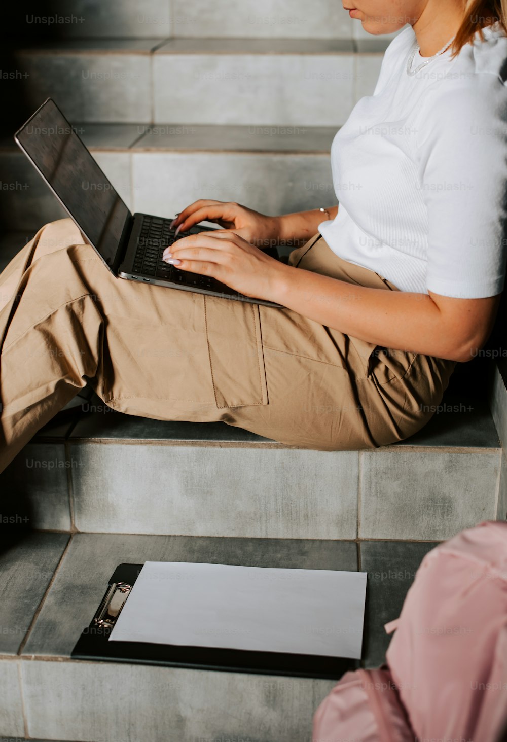 a woman sitting on steps using a laptop computer