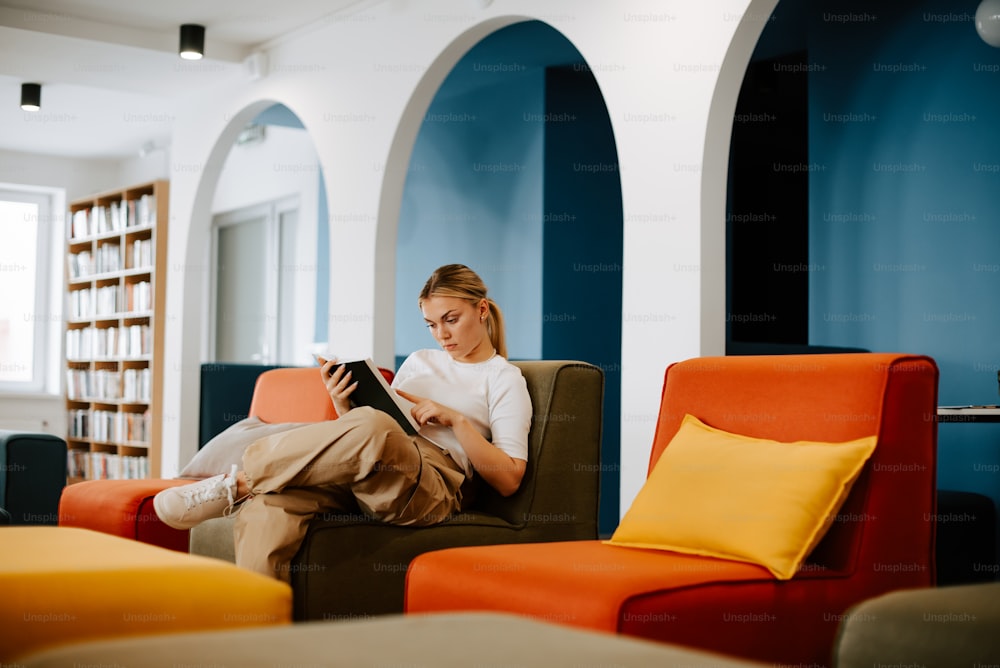 a woman sitting in a chair reading a book