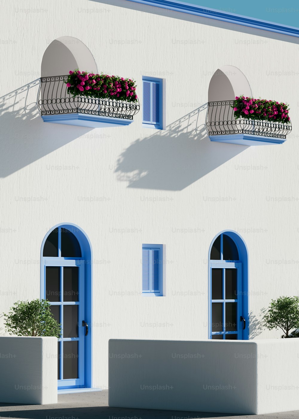 Un edificio blanco con ventanas azules y un balcón