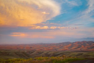 a scenic view of a valley and mountains under a cloudy sky