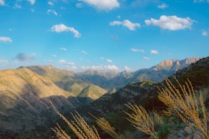 a view of a mountain range with a few clouds in the sky