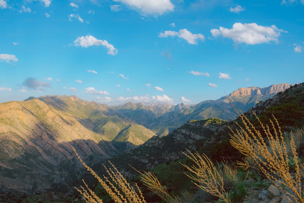 a view of a mountain range with a few clouds in the sky