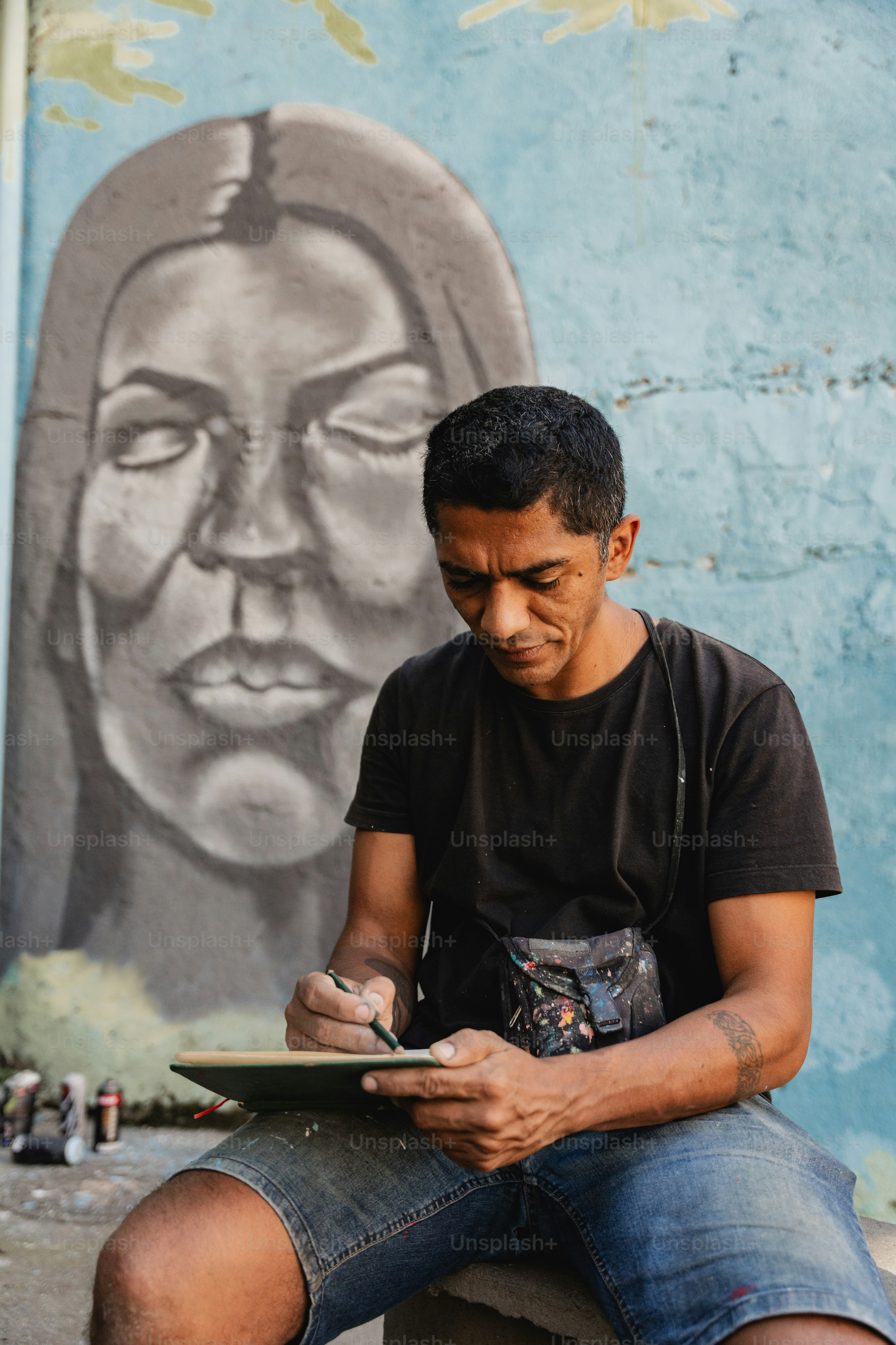 a man sitting on a bench writing on a piece of paper