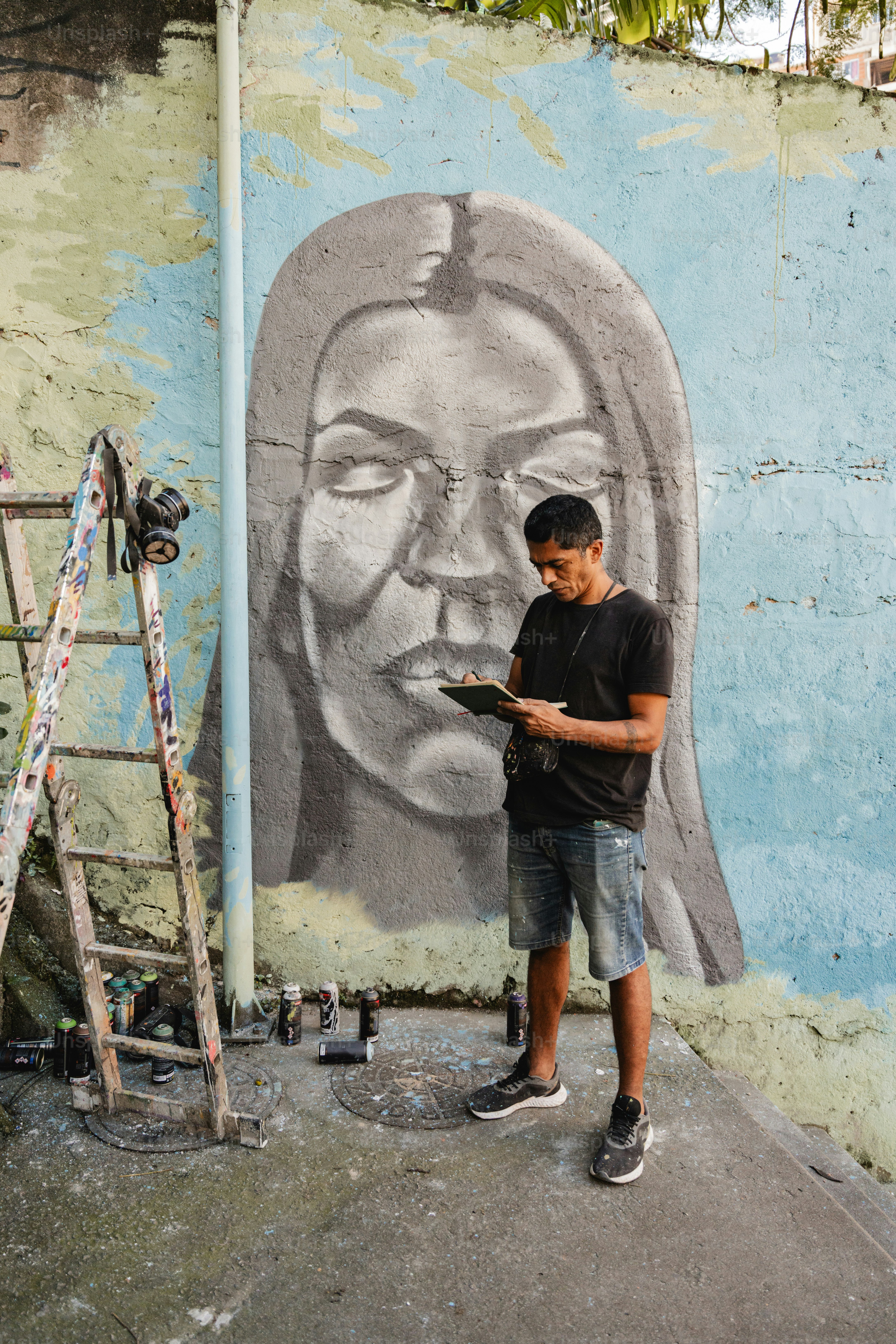 a man standing in front of a wall with a painting on it