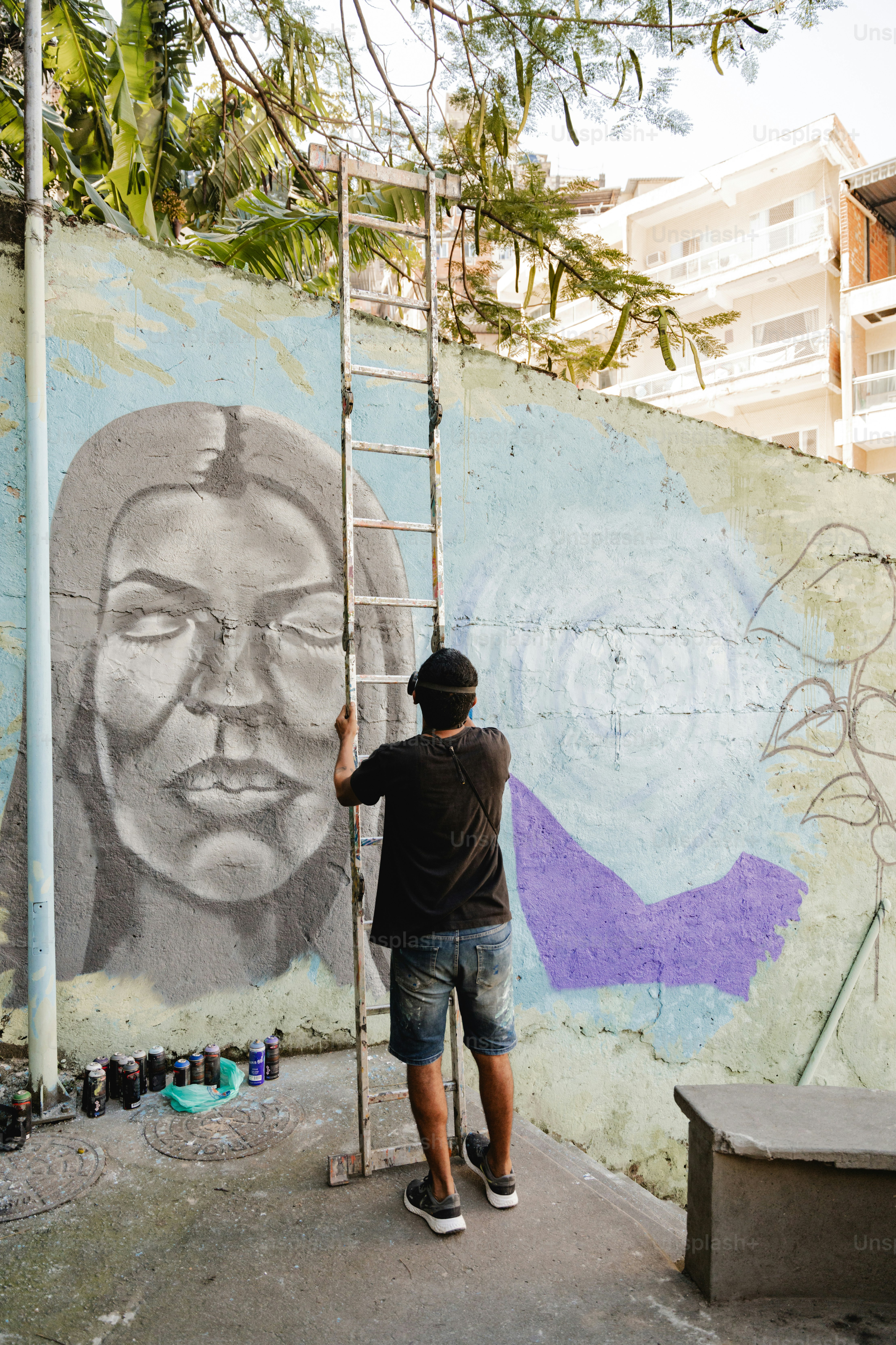 a man painting a mural on the side of a building