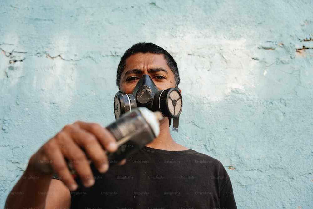 a man wearing a gas mask and holding a can