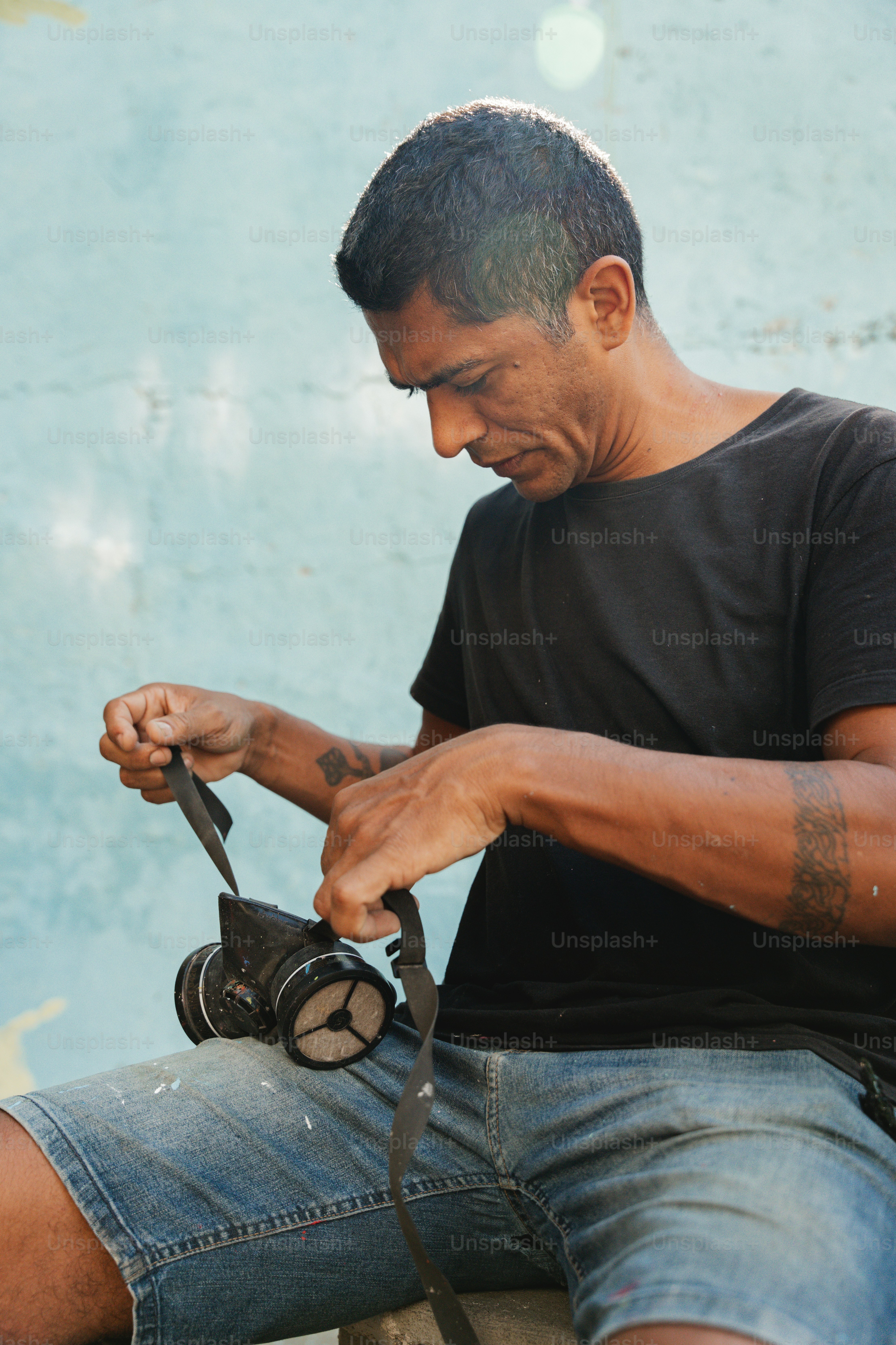 a man sitting on a bench holding a camera
