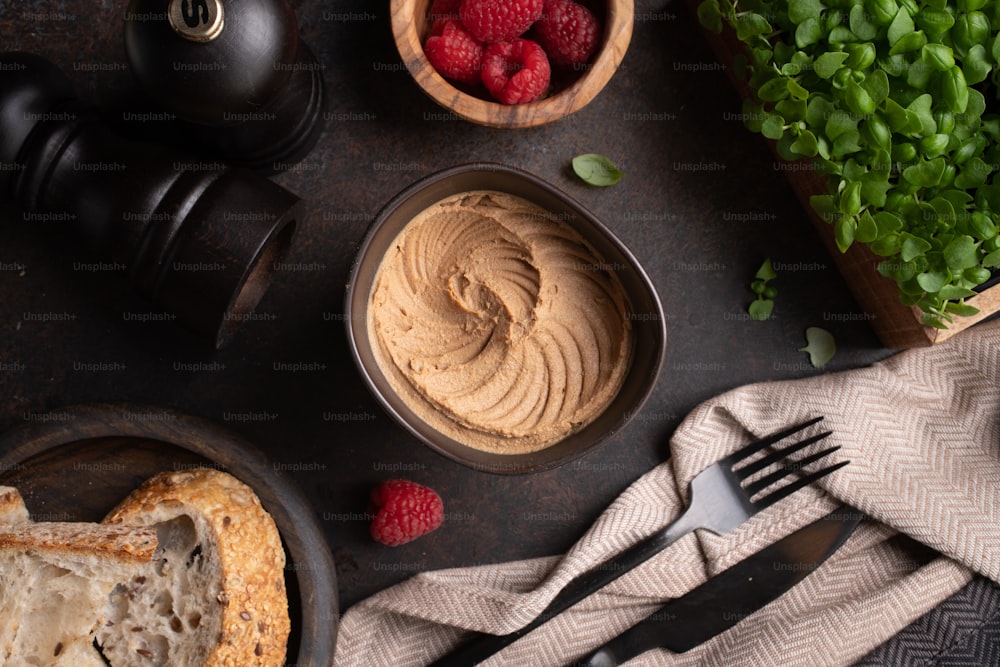 a table topped with bread and raspberries next to a knife and fork