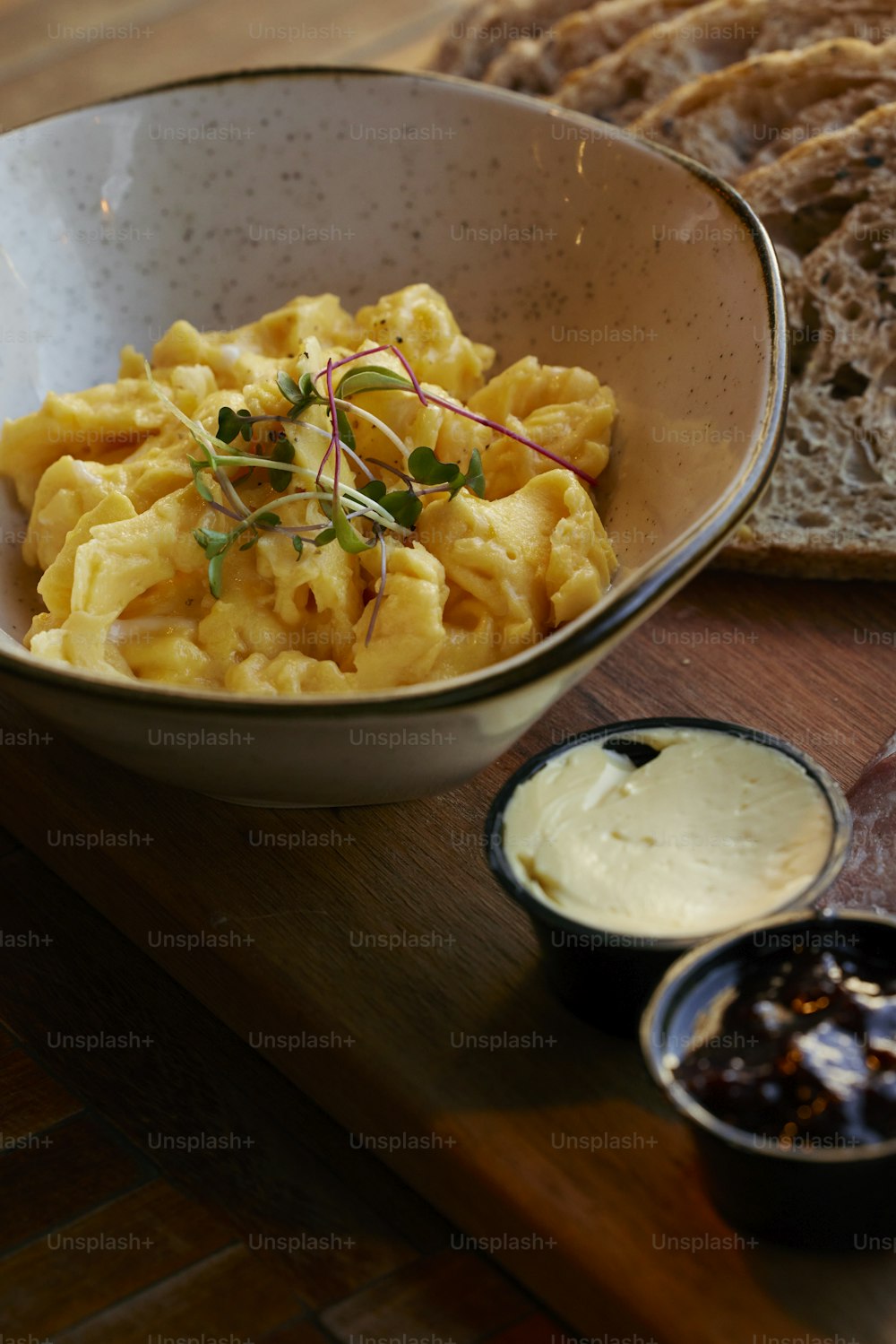 a bowl of macaroni and cheese next to a loaf of bread