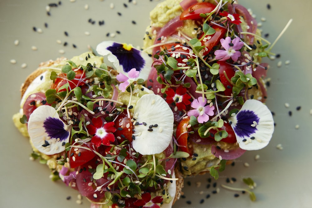 a white plate topped with two pieces of bread covered in veggies