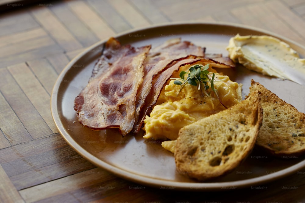 a plate of eggs, toast, and bacon on a table