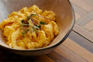 a bowl of macaroni and cheese on a wooden table
