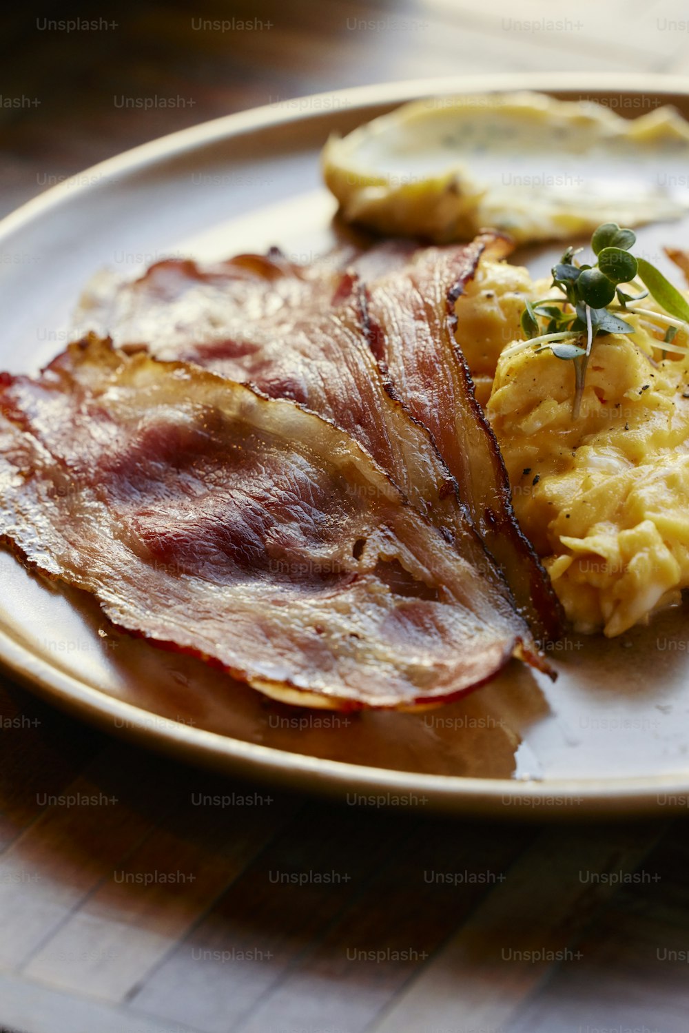 a white plate topped with bacon and eggs