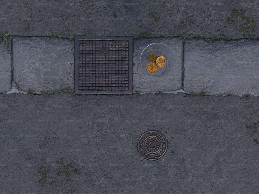 a drain in the middle of a sidewalk with a plate of food on it