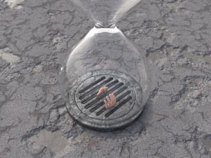 a metal grate sitting on top of a dirty ground