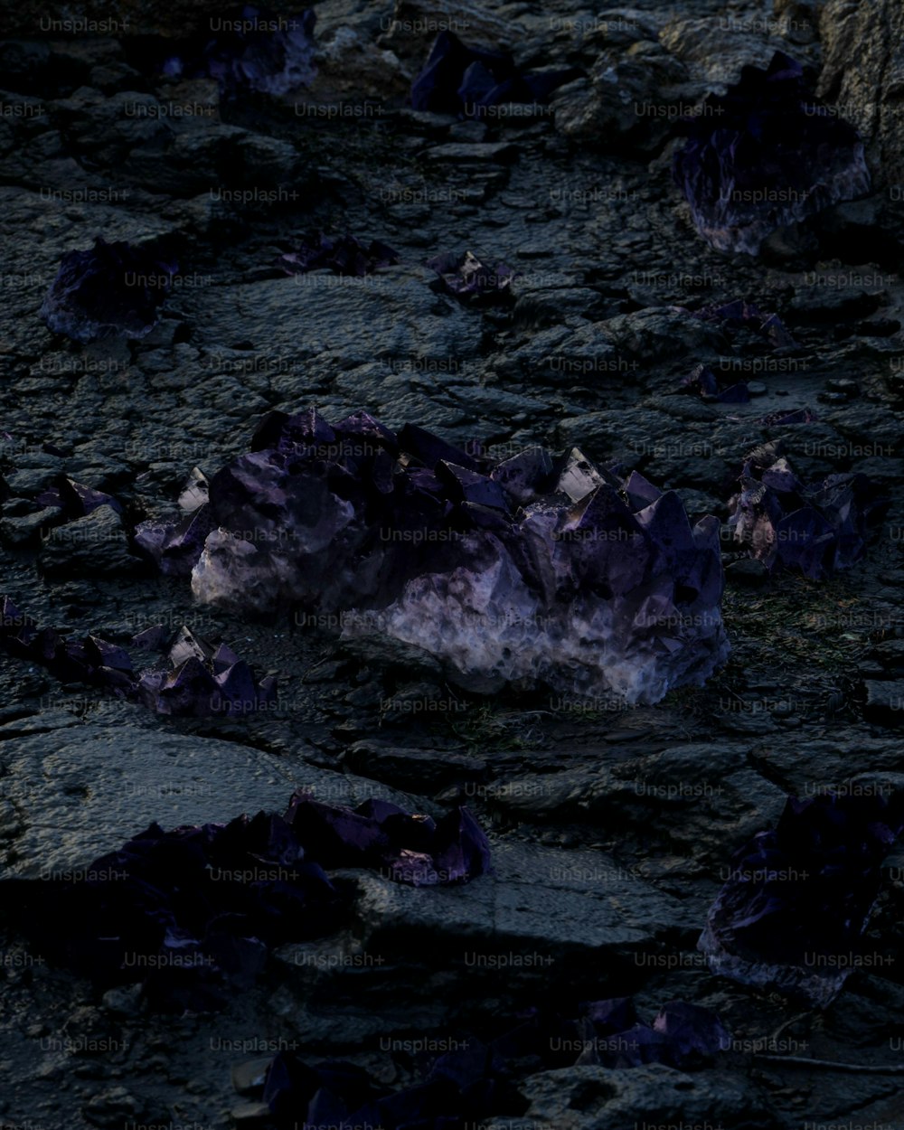a rock formation with purple rocks on the ground