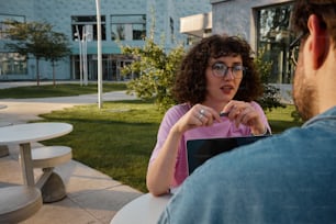 a man and a woman sitting at a table outside