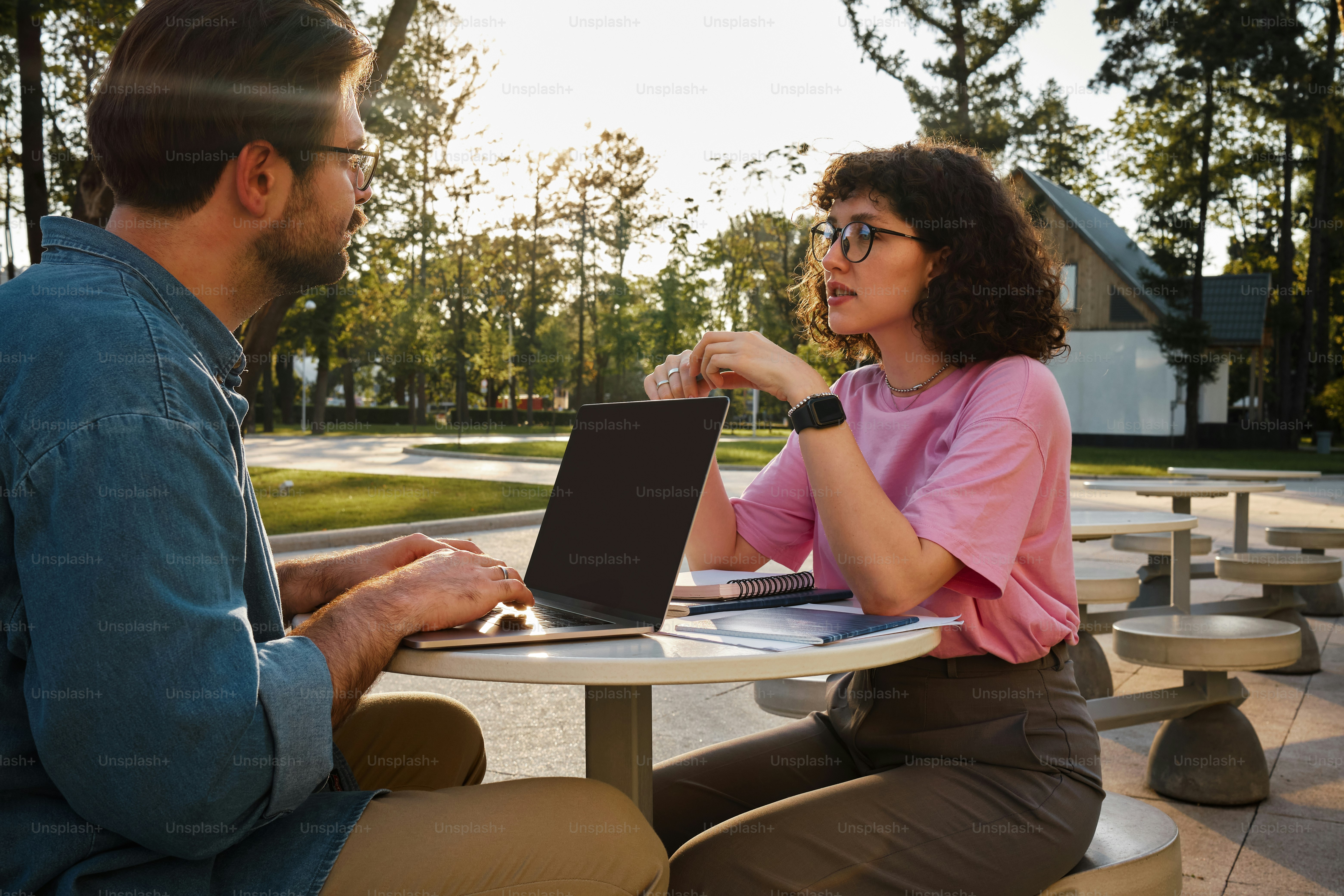 Un homme et une femme assis à une table avec un ordinateur portable