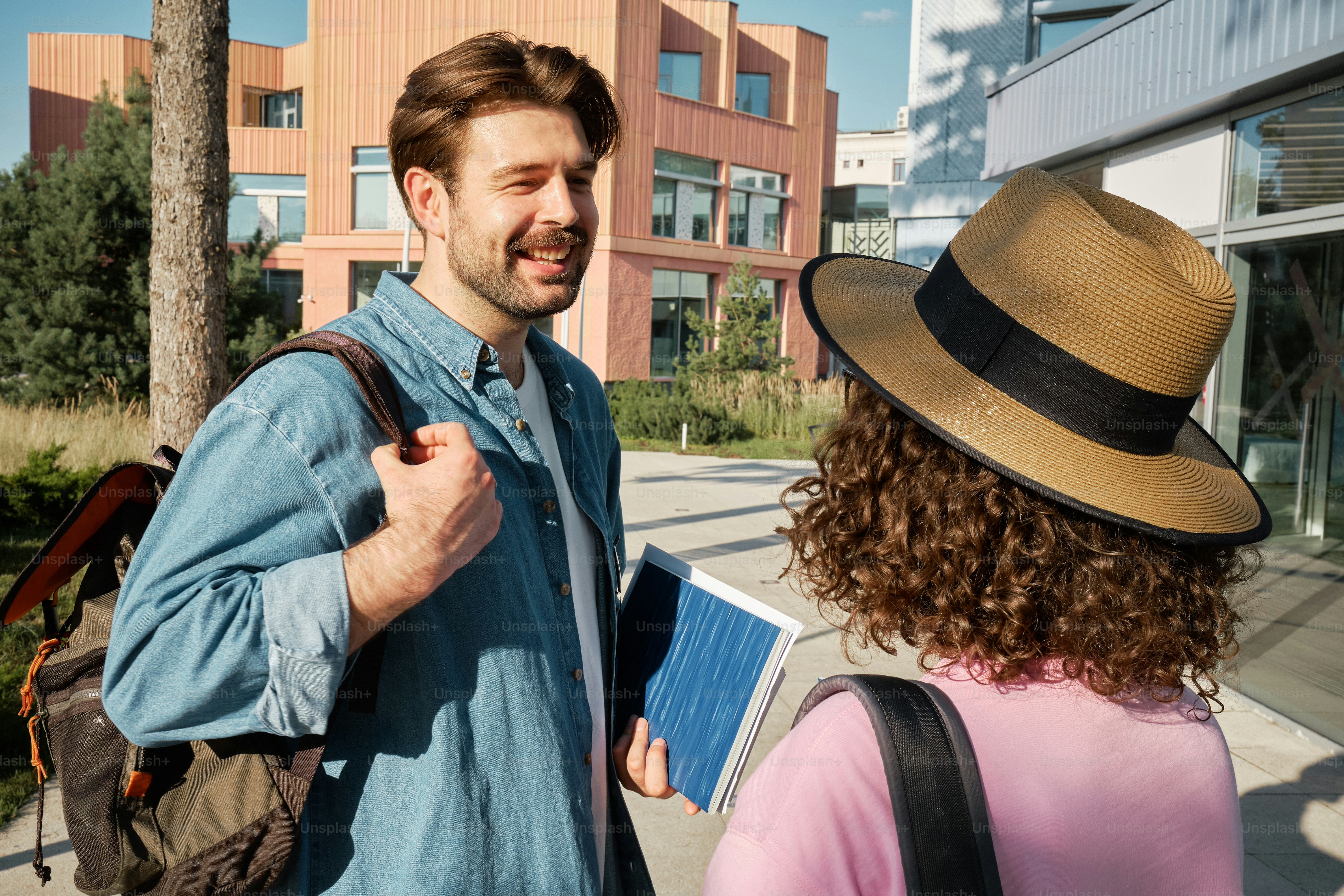 Un homme coiffé d’un chapeau parlant à une femme