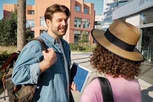 a man in a hat talking to a woman