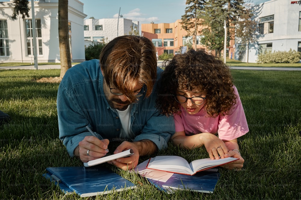 Un homme et une petite fille sont allongés dans l’herbe