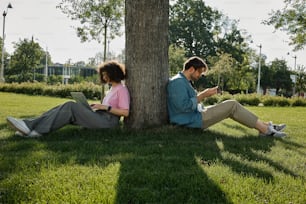a man and a woman sitting under a tree