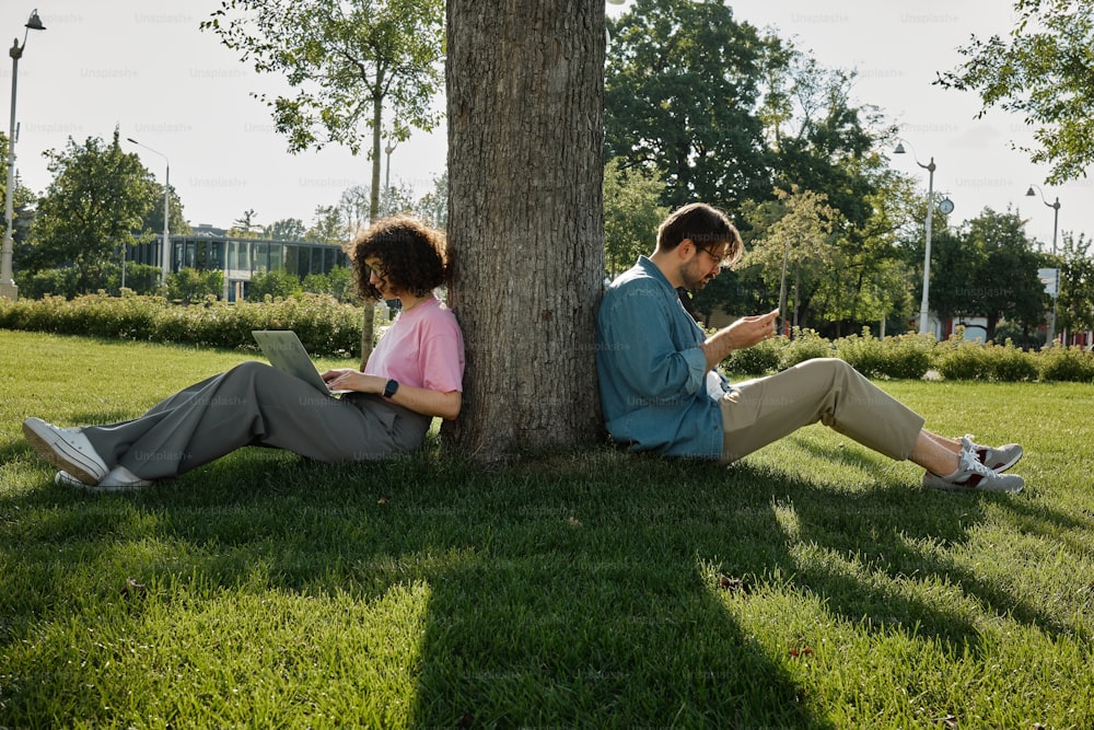 a man and a woman sitting under a tree