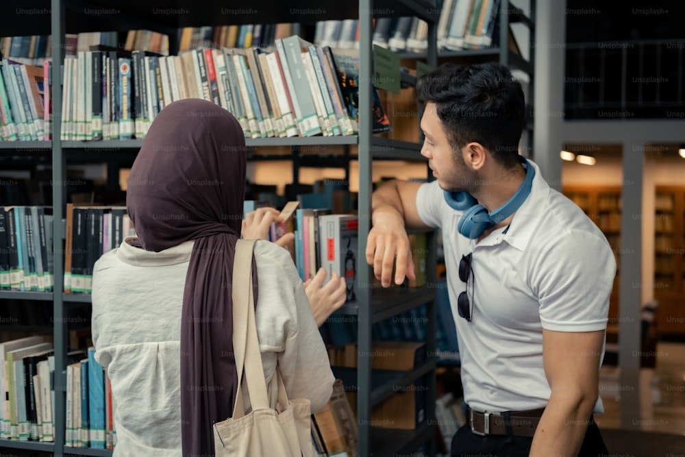 a man standing next to a woman in front of a book shelf