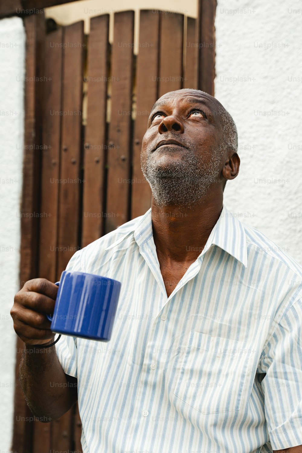 Un hombre sosteniendo una taza azul en la mano