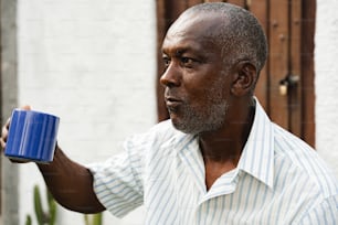 a man holding a blue cup in his hand