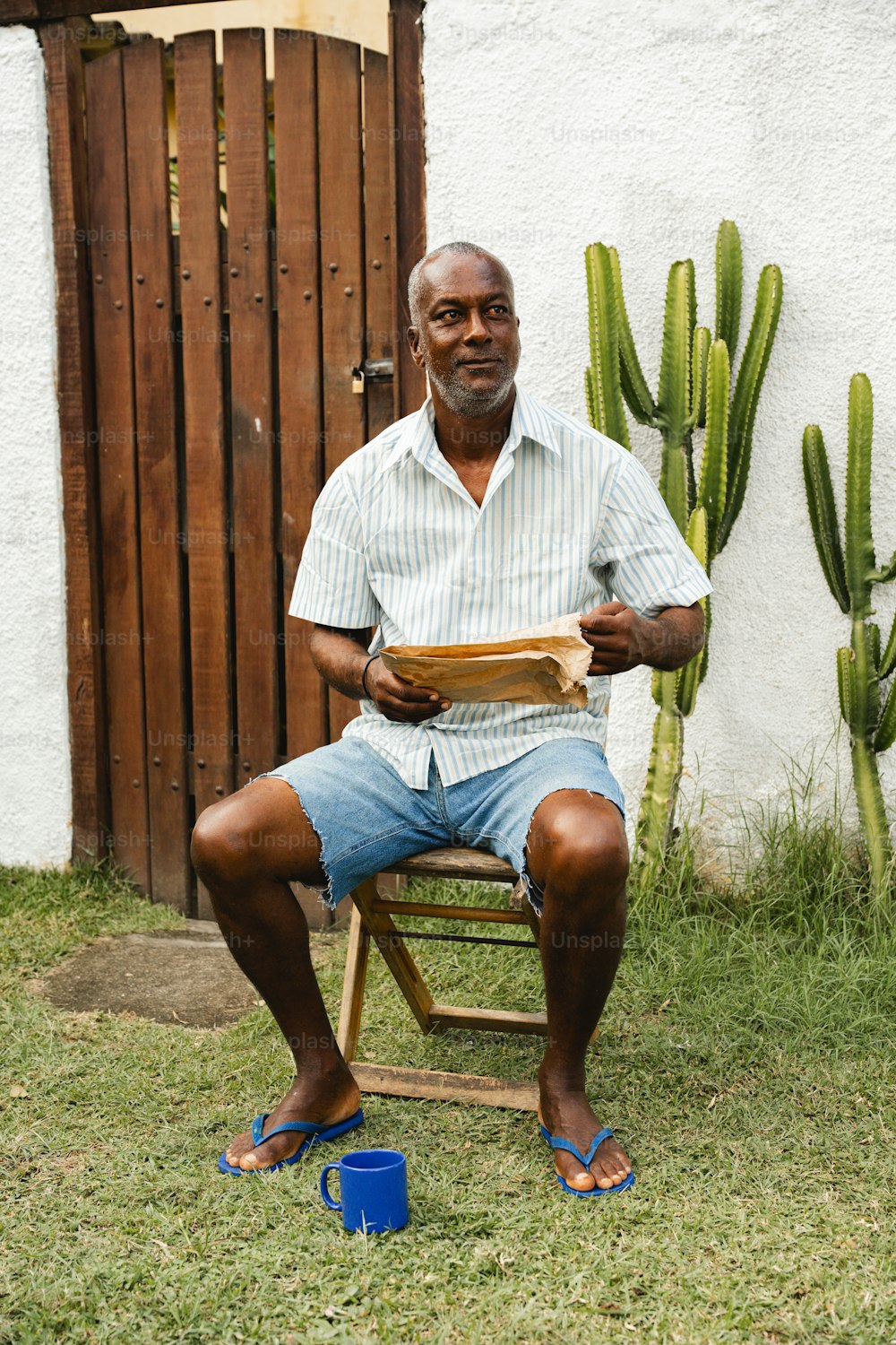a man sitting on a chair in front of a cactus