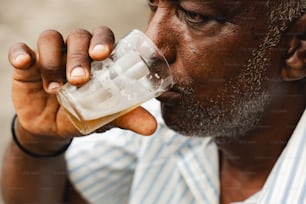 Um homem está bebendo um copo de cerveja
