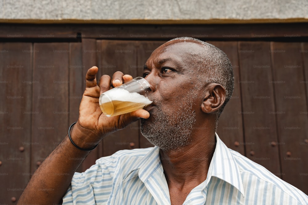 a man drinking from a glass of beer