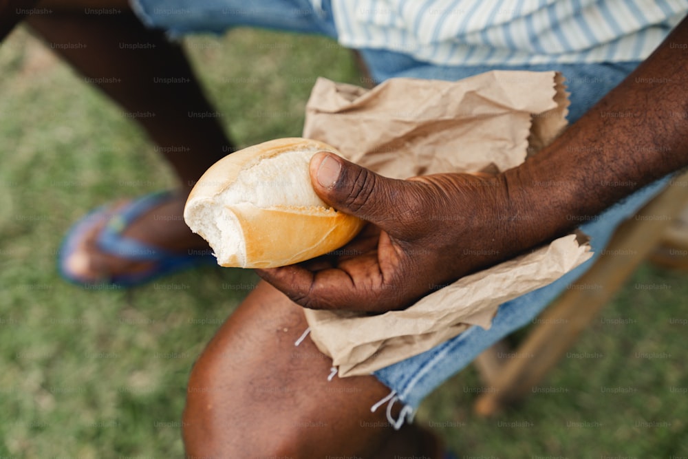 a man holding a piece of bread in his hand